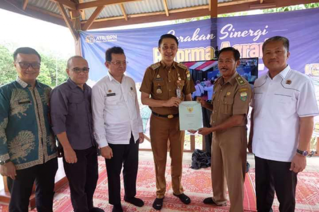 Gerakan Sinergi Reporma Agraria, Pj Bupati Bachyuni Serahkan Sertifikat Tanah di Danau Bata Desa Tangkit